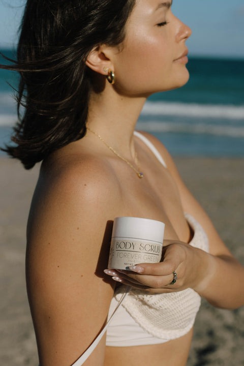 woman holding body scrub in hand