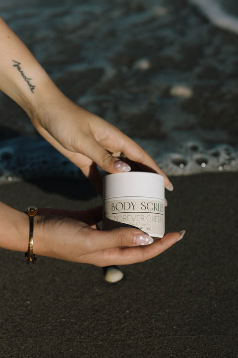 hands holding body scrub over beach